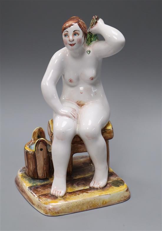 A Russian faience figure of a seated nude woman